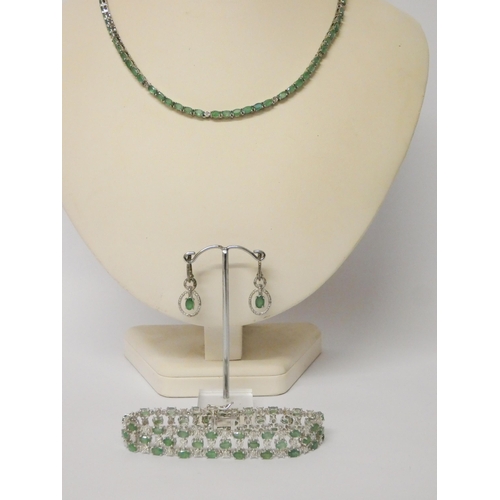 470 - Silver and emerald necklace and a pair of matching drop earrings and a wide paste set bracelet