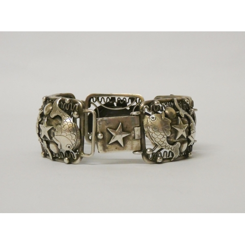 500 - A silver wide panel bracelet, decorated with nautical/seaside motifs, unmarked. Length 18.5 cms