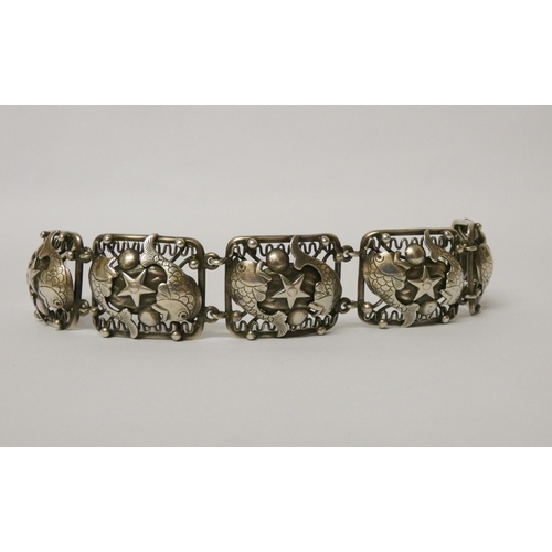 500 - A silver wide panel bracelet, decorated with nautical/seaside motifs, unmarked. Length 18.5 cms