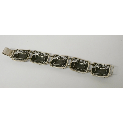 500 - A silver wide panel bracelet, decorated with nautical/seaside motifs, unmarked. Length 18.5 cms