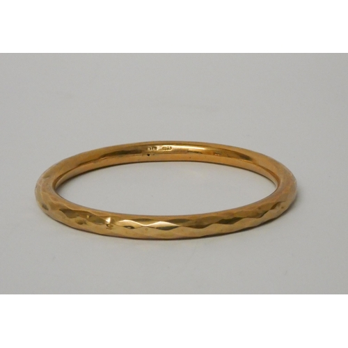 503 - A 9ct gold bangle with faceted edges, hallmarked. 9.2g