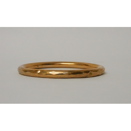 503 - A 9ct gold bangle with faceted edges, hallmarked. 9.2g