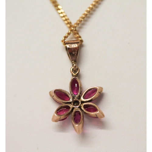 533 - A ruby and diamond flower head pendant on 9ct gold chain.6.5 grams gross weight