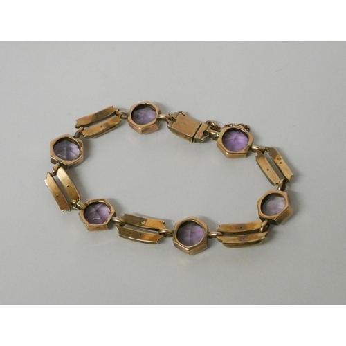 551 - An Art Deco amethyst bracelet, set with six hexagonal collet set amethysts on rose gold bar link cha... 