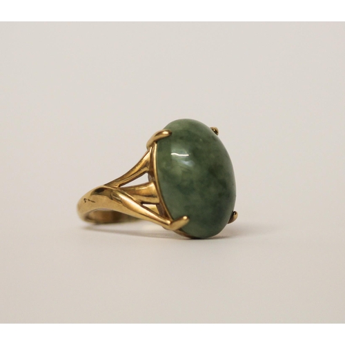 559 - A large oval jade cabochon dress ring on 9ct yellow gold band, hallmarked, ring size Q, gross weight... 