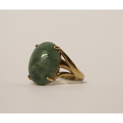 559 - A large oval jade cabochon dress ring on 9ct yellow gold band, hallmarked, ring size Q, gross weight... 