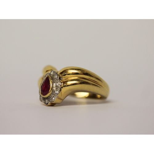 594 - A ruby and diamond ring, the tear drop4.8g ruby and diamond cluster mounted on a wide wishbone setti... 