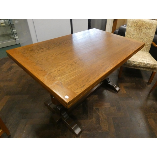 165 - An antique style oak drawer leaf table on carved cup and cover supports