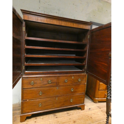 185 - A Georgian mahogany linen press, two shell inlaid cupboard doors with sliders within on a two short ... 