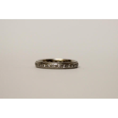 521 - A modern platinum channel set diamond eternity ring, 3/4 set with brilliant cut diamonds. Hallmarked... 