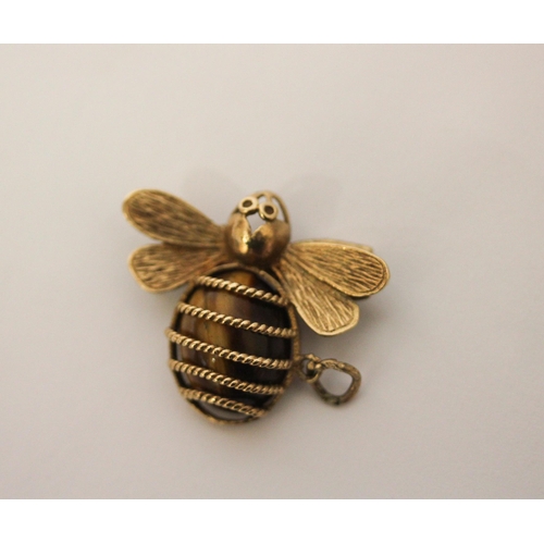 554 - A bee design pendant in hallmarked 9ct gold with tiger's eye body. 30mm across