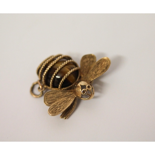 554 - A bee design pendant in hallmarked 9ct gold with tiger's eye body. 30mm across