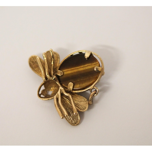 554 - A bee design pendant in hallmarked 9ct gold with tiger's eye body. 30mm across