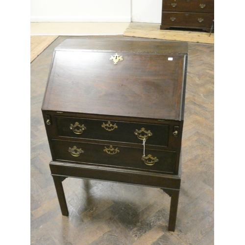 163 - A mahogany bureau fitted two long drawers with brass handles standing on square legs, 27