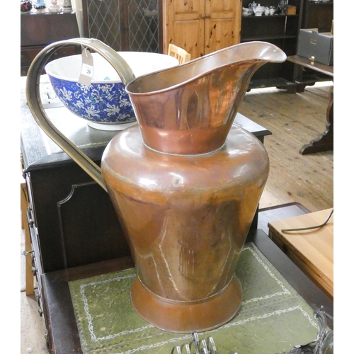 39 - A very large copper water jug with brass handle, 22