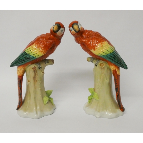 238 - Pair of Sitzendorf porcelain parrots, naturalistically modelled seated on tree stumps, blue printed ... 