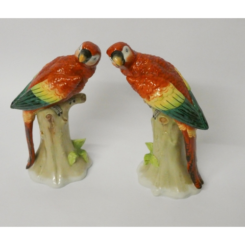 238 - Pair of Sitzendorf porcelain parrots, naturalistically modelled seated on tree stumps, blue printed ... 