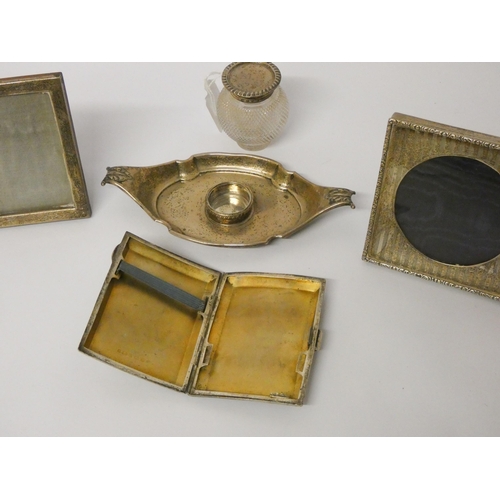 650 - A silver cigarette case, two small silver photograph frames and a silver boat shaped inkstand with c... 