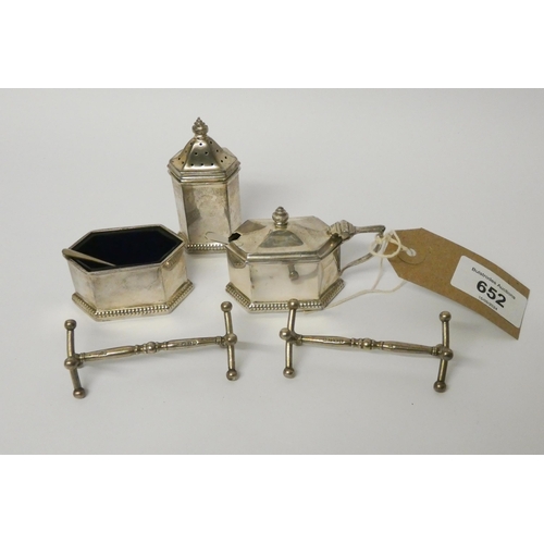 652 - A pair of 19th century silver knife rests, London 1833/34 and a three piece silver cruet set with bl... 