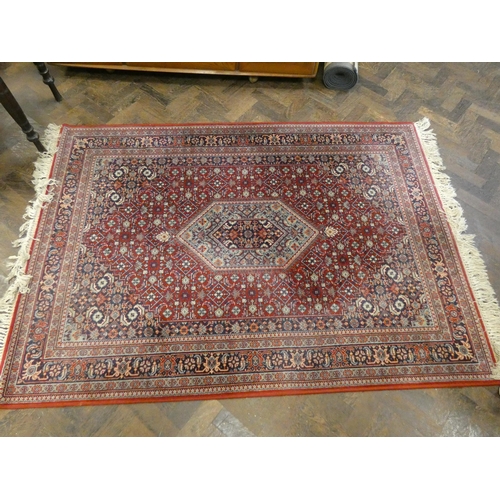 160 - A large red and patterned Wilton style rug, matching hall runner and one other smaller matching rug ... 