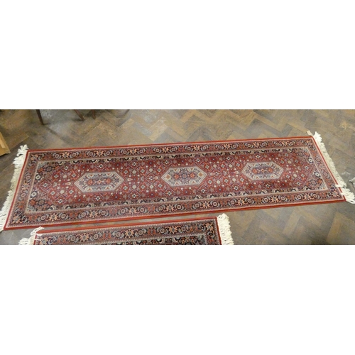 160 - A large red and patterned Wilton style rug, matching hall runner and one other smaller matching rug ... 