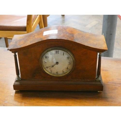 174 - An Edwardian mantle clock in an inlaid walnut case with brass pillars