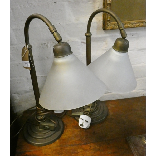 179 - A pair of brass Corinthian column shaped table lamps with frosted glass shades