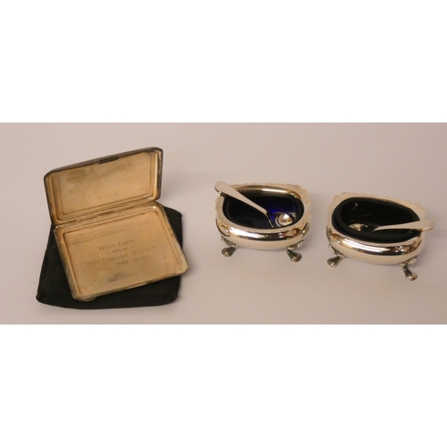 673 - An Art Deco silver compact with silk cover and a pair of silver plated salt cellars with blue glass ... 