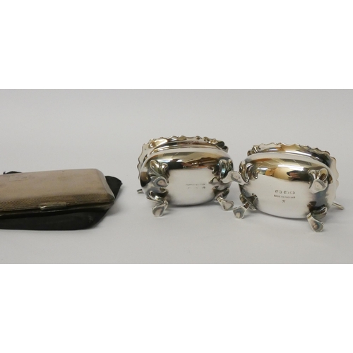 673 - An Art Deco silver compact with silk cover and a pair of silver plated salt cellars with blue glass ... 