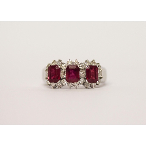 515 - A modern three stone ruby and diamond ring, three emerald cut rubies weighing 1.6 carat total, each ... 