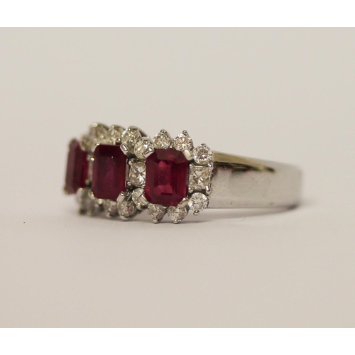 515 - A modern three stone ruby and diamond ring, three emerald cut rubies weighing 1.6 carat total, each ... 