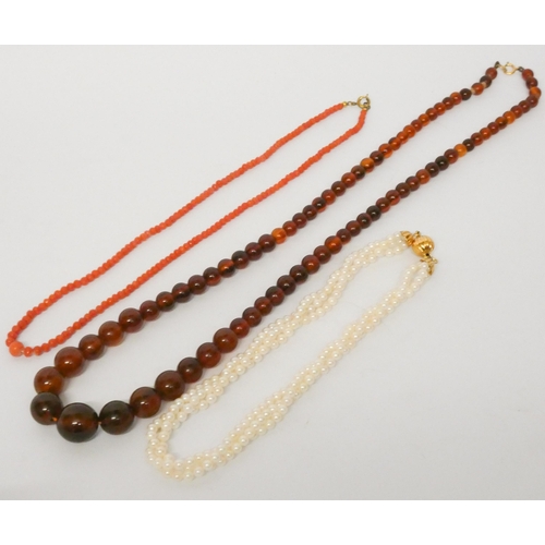 534 - An amber graduated amber bead necklace with 9ct gold clasp, a triple row of choker length cultured p... 