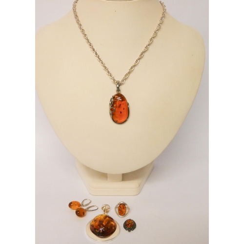 556 - Two large modern silver and amber pendants, silver chain, pair of drop earring, dress ring etc.