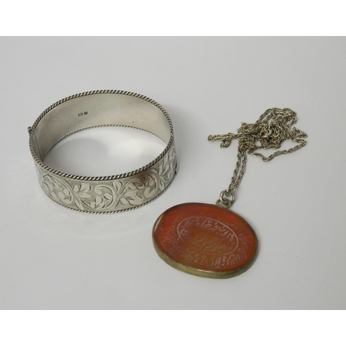 513 - A silver hinged bangle and an Arabic pendant on German 835 silver chain