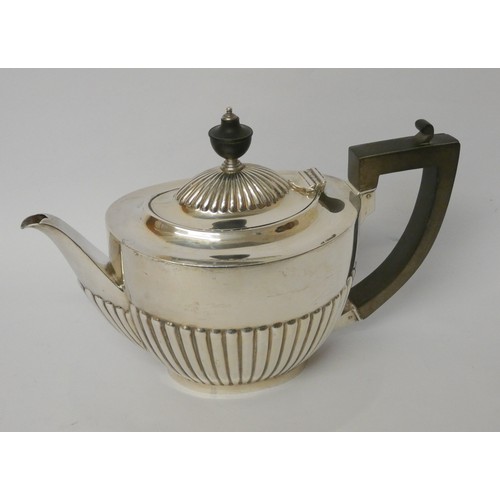 641 - A silver teapot, of half lobed design with ebony handle, hallmarked Sheffield 1923, gross weight 19.... 