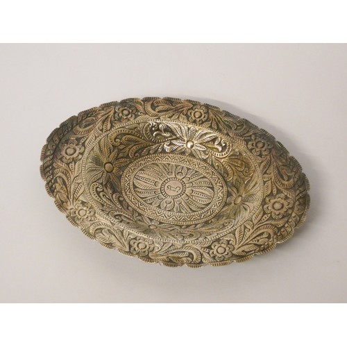 643 - An Eastern white metal dish, of oval form with engraved decoration. 15.5 cms across, 2.5 oz