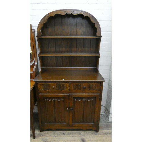 27 - A reproduction oak Dutch style dresser with linen fold panel doors and drawers under, 37