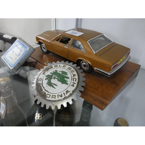 335 - A model car on wooden plaque and two car badges