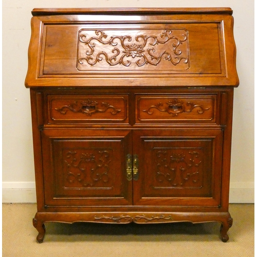 147 - A Chinese mahogany bureau with carved panels comprising two drawers and cupboards under, 3' wide