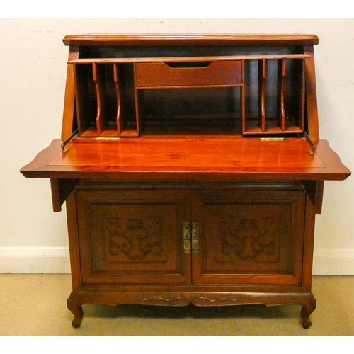 147 - A Chinese mahogany bureau with carved panels comprising two drawers and cupboards under, 3' wide