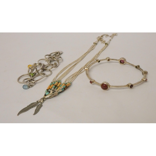 544 - A large silver bangle with inset garnets, Navajo style liquid silver necklace, Longchamp bracelet.