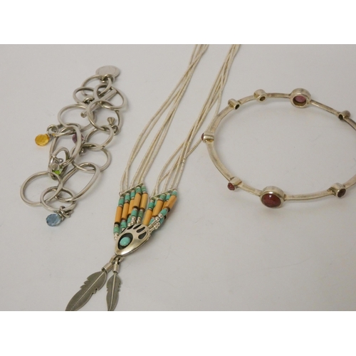 544 - A large silver bangle with inset garnets, Navajo style liquid silver necklace, Longchamp bracelet.