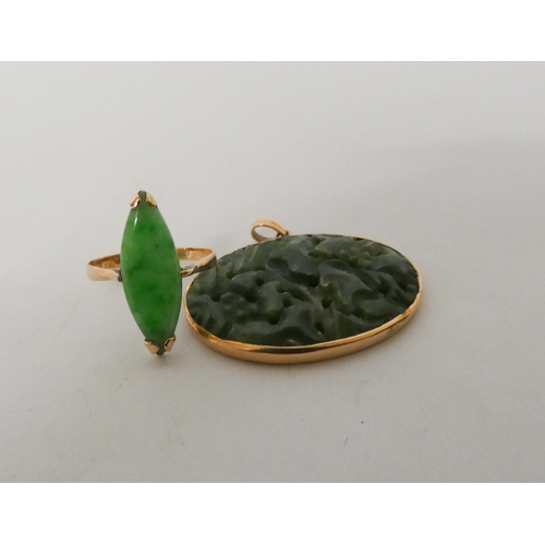 622 - An oval pierced jade pendant in gold frame and a marquis shaped ring with Chinese character hallmark... 