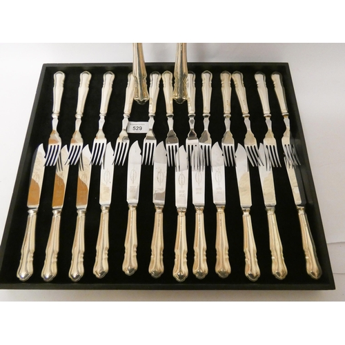 529 - A set of twelve silver handled fish knives and forks together with a pair of silver handled matching... 