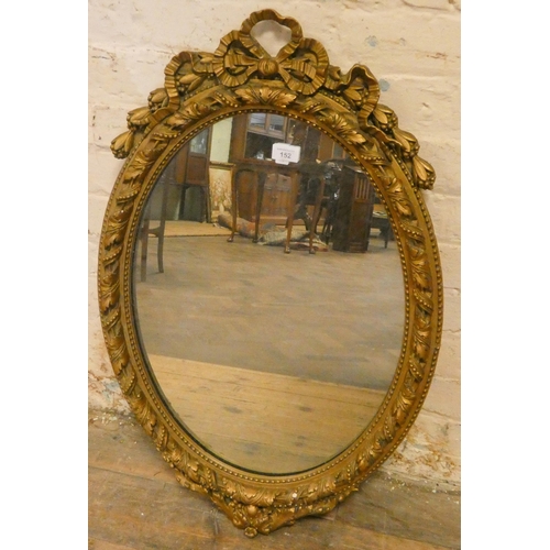 152 - A Victorian oval bevelled wall mirror in decorative gilt frame