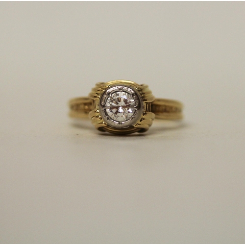 597 - A modern solitaire diamond ring, in a rub over circular setting on 18ct yellow band. Marked 18ct. Ri... 