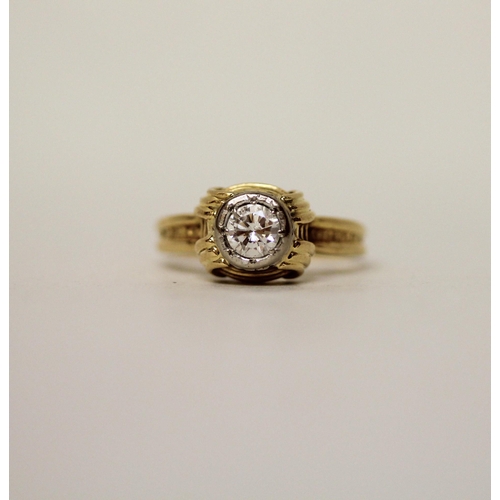 597 - A modern solitaire diamond ring, in a rub over circular setting on 18ct yellow band. Marked 18ct. Ri... 