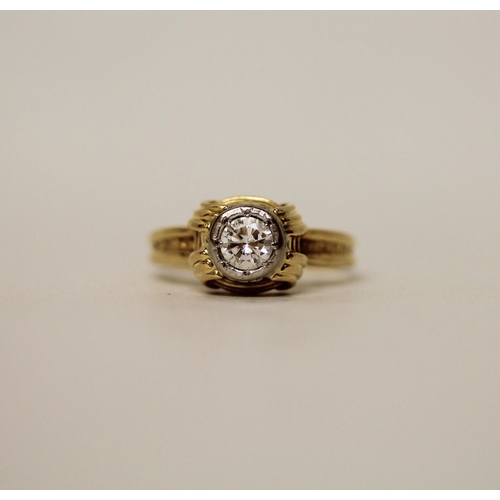 597 - A modern solitaire diamond ring, in a rub over circular setting on 18ct yellow band. Marked 18ct. Ri... 