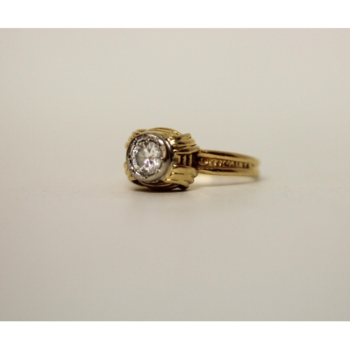 597 - A modern solitaire diamond ring, in a rub over circular setting on 18ct yellow band. Marked 18ct. Ri... 