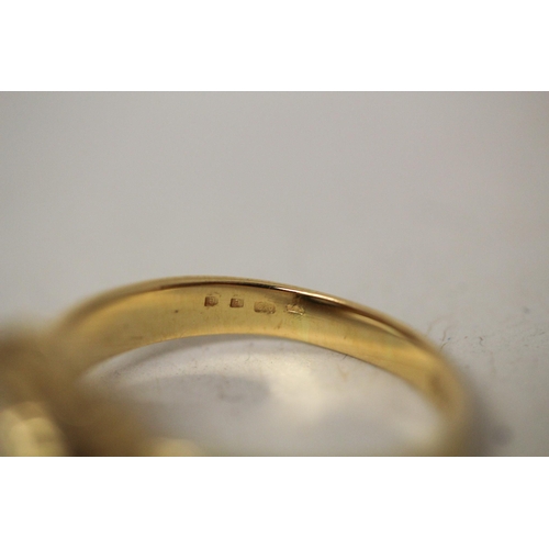 597 - A modern solitaire diamond ring, in a rub over circular setting on 18ct yellow band. Marked 18ct. Ri... 